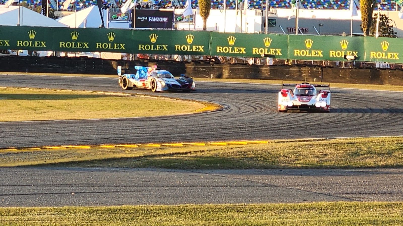 Prototype racecars on the Daytona infield road course in afternoon light