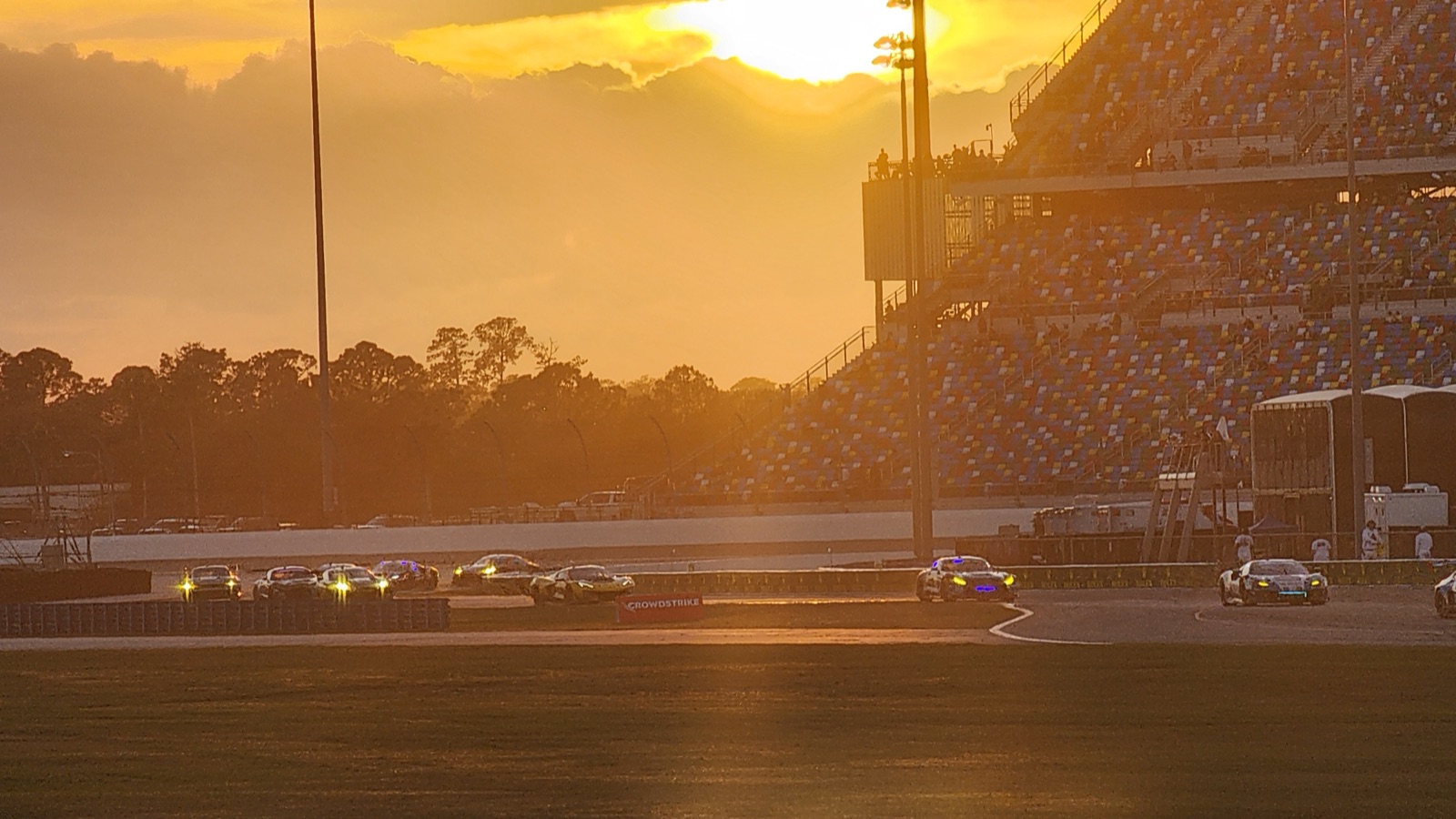 Rolex 24 at Daytona, sunset over the speedway with cars on track